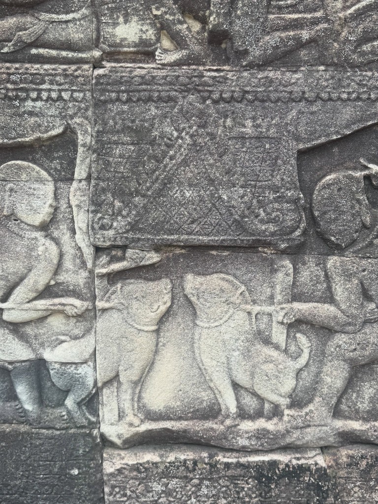 A relief panel showing two animals squared off against each other, people gathered around watching