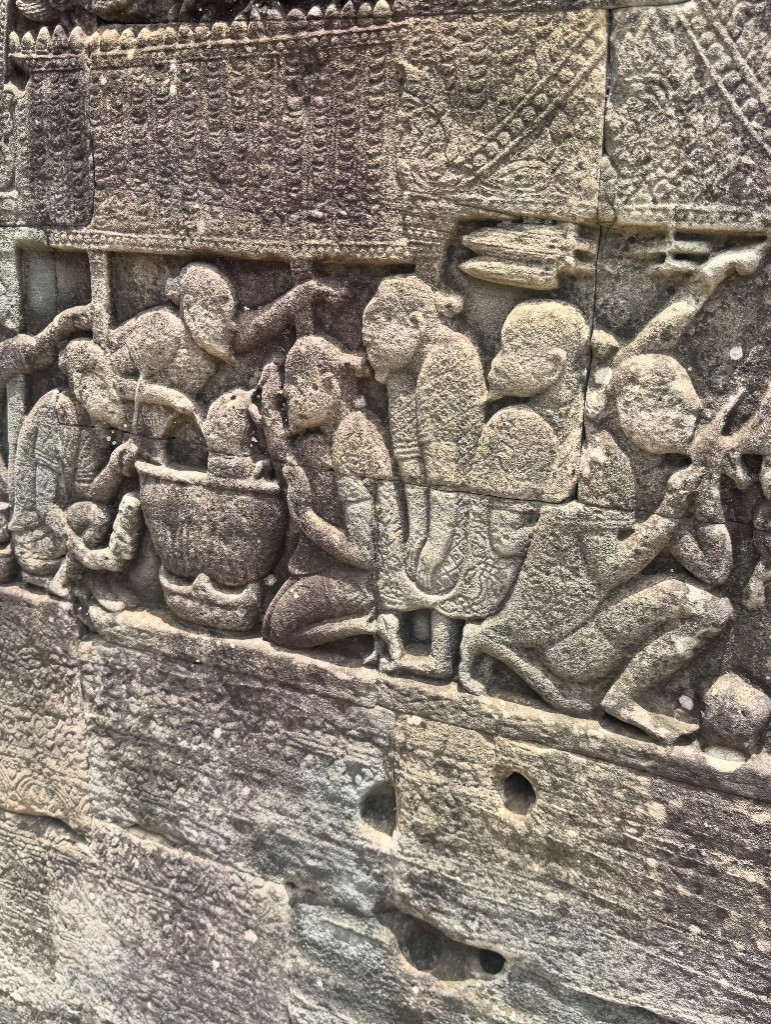 A tightly packed close up of carved figures on the gallery wall