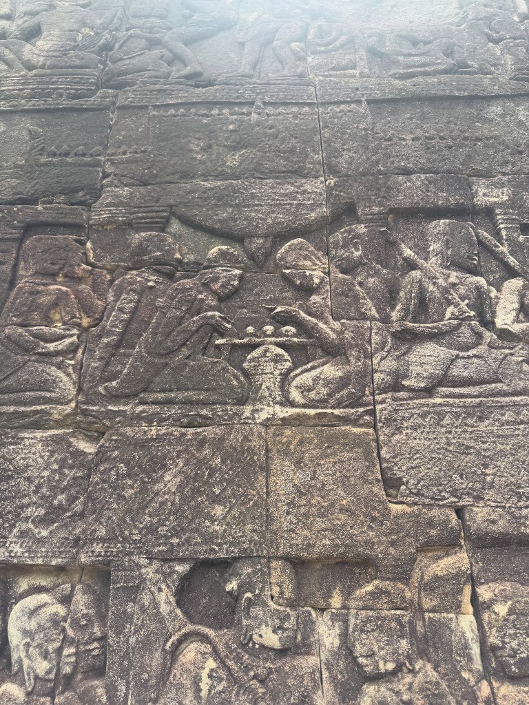 A carved panel showing two figures playing a board game, exactly the kind of everyday detail our guide pointed out