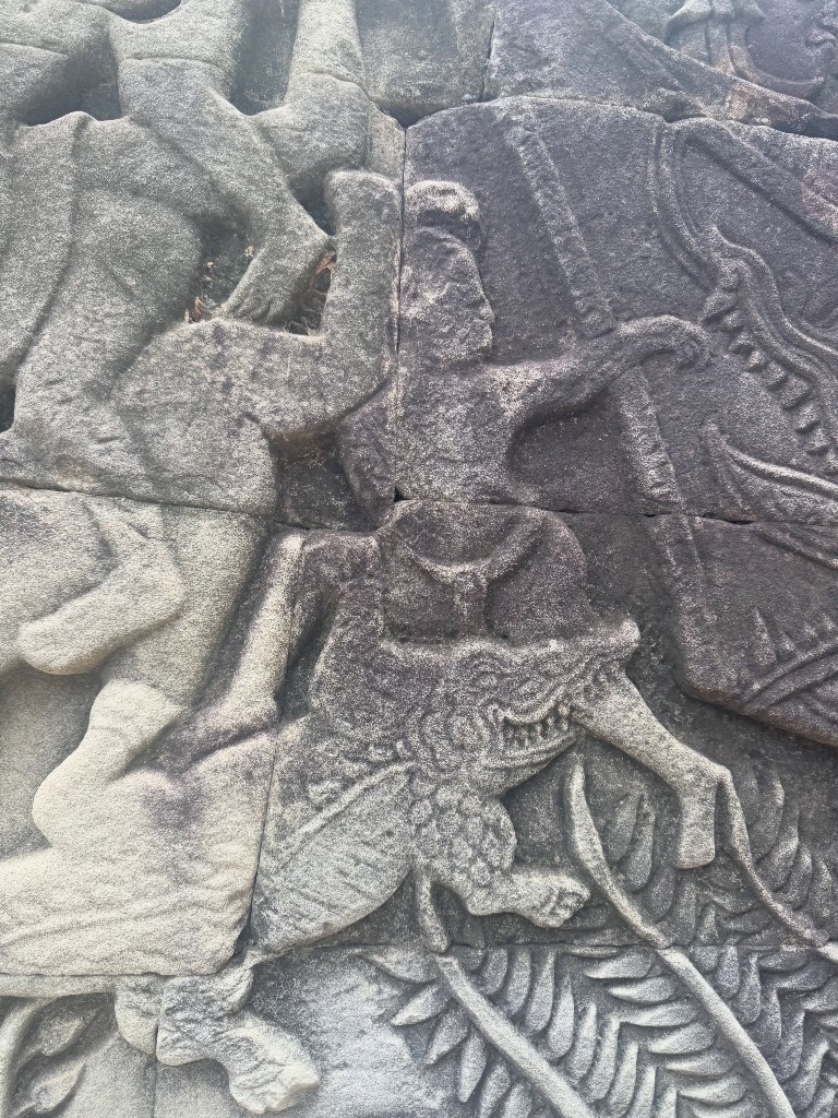 A close up of a warrior carved into the outer gallery wall, mounted on a creature mid-battle